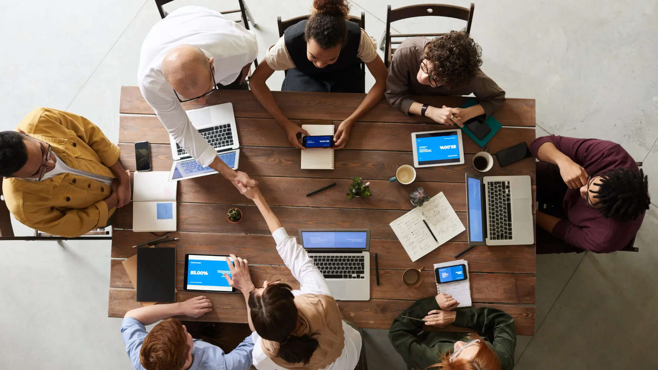 Business team meeting and shaking hands at table, selecting the right digital marketing agency